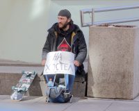 бездомный просит милостыню