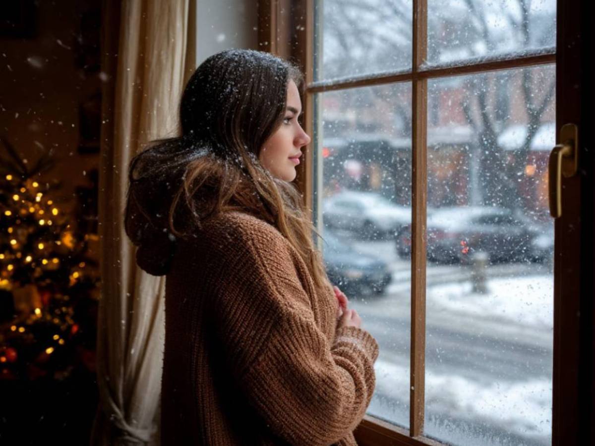 Девушка смотрит на заснеженную улицу