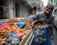 Продавец на рынке фасует картофель