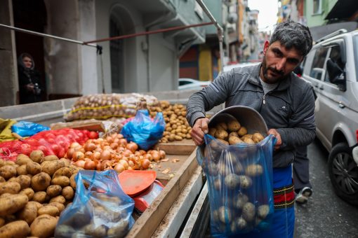 Продавец на рынке фасует картофель