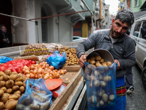 Продавец на рынке фасует картофель