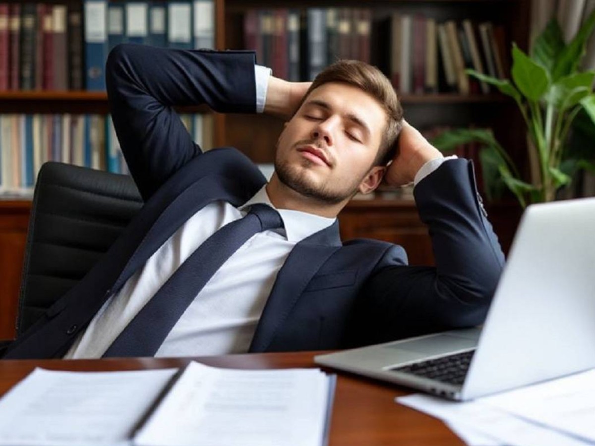 Офис-менеджер отдыхает за рабочим столом