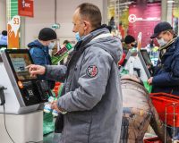 Мужчина расплачивается у кассы самообслуживания