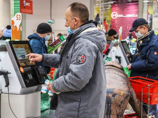 Мужчина расплачивается у кассы самообслуживания