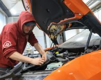 человек ремонтирует двигатель авто